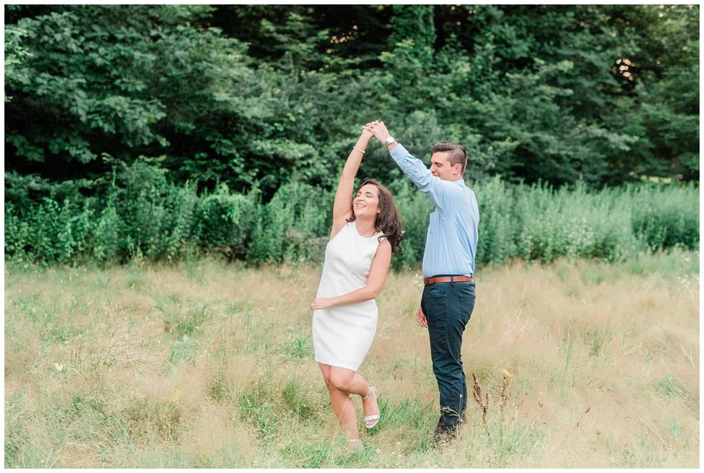 A couple dances together in a tall grassy field.