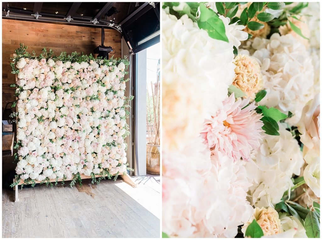 A flower wall backdrop with cream and pink fluffly florals.