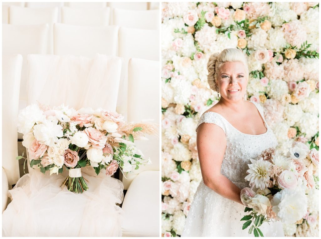 The bride holds her bouquet in front of a flower wall.