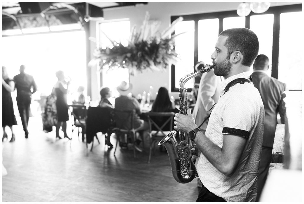 A musician plays the saxophone during cocktail hour.