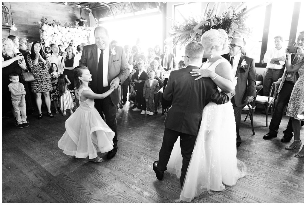 The bride and groom dance with their children for a first dance as a family.