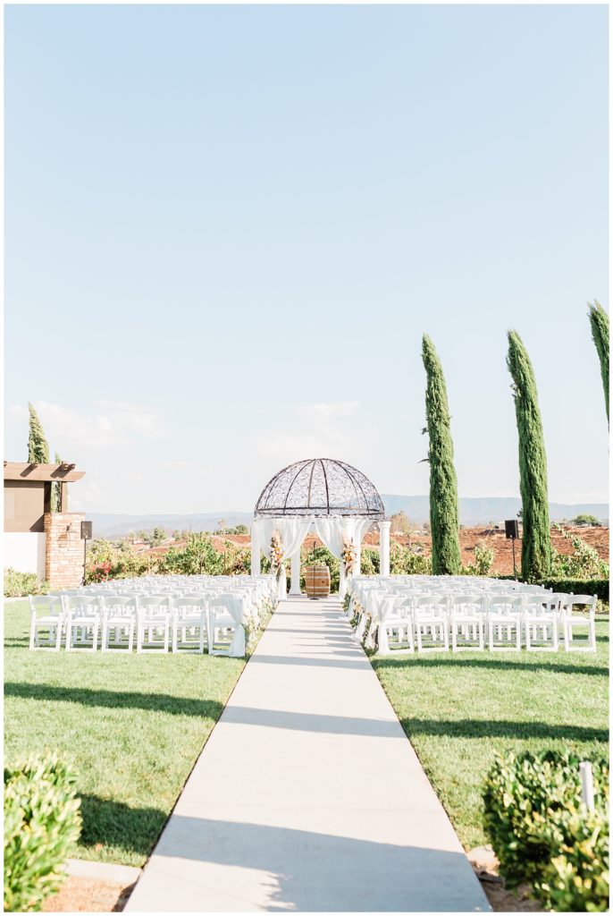 Ceremony site is set for a wedding at Avensole Winery wedding venue on a sunny day in Temecula, California.