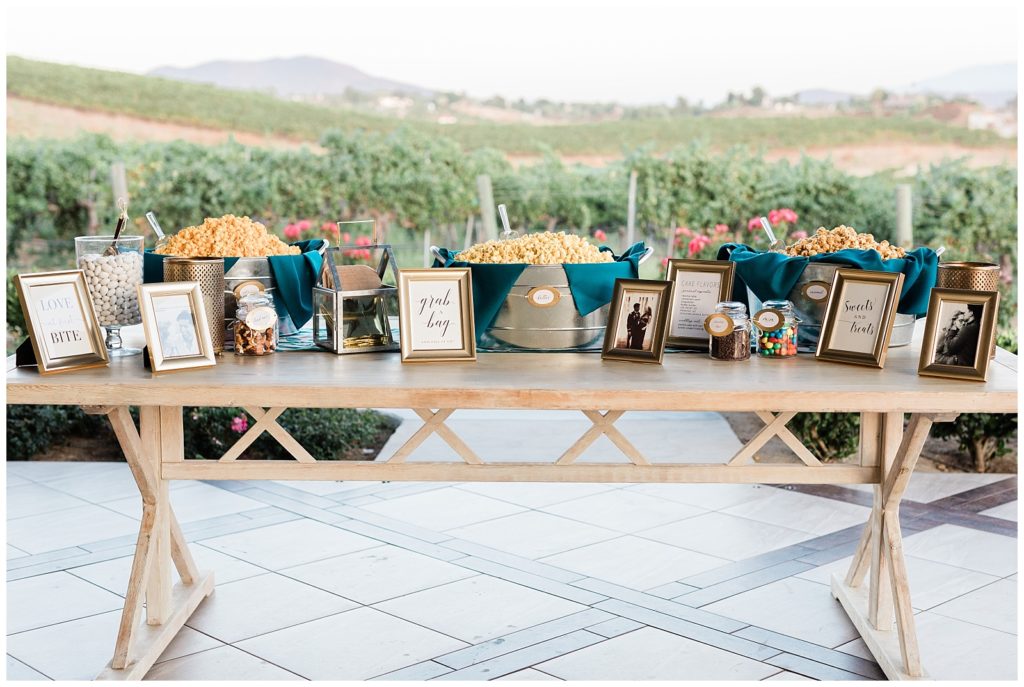 The popcorn favors table is set up on the outdoor area of the Avensole Winery wedding venue in Temecula, California.