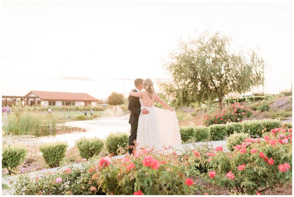 A bride and groom pose for portraits in front of a pond at Avensole Winery in Temecula, California.