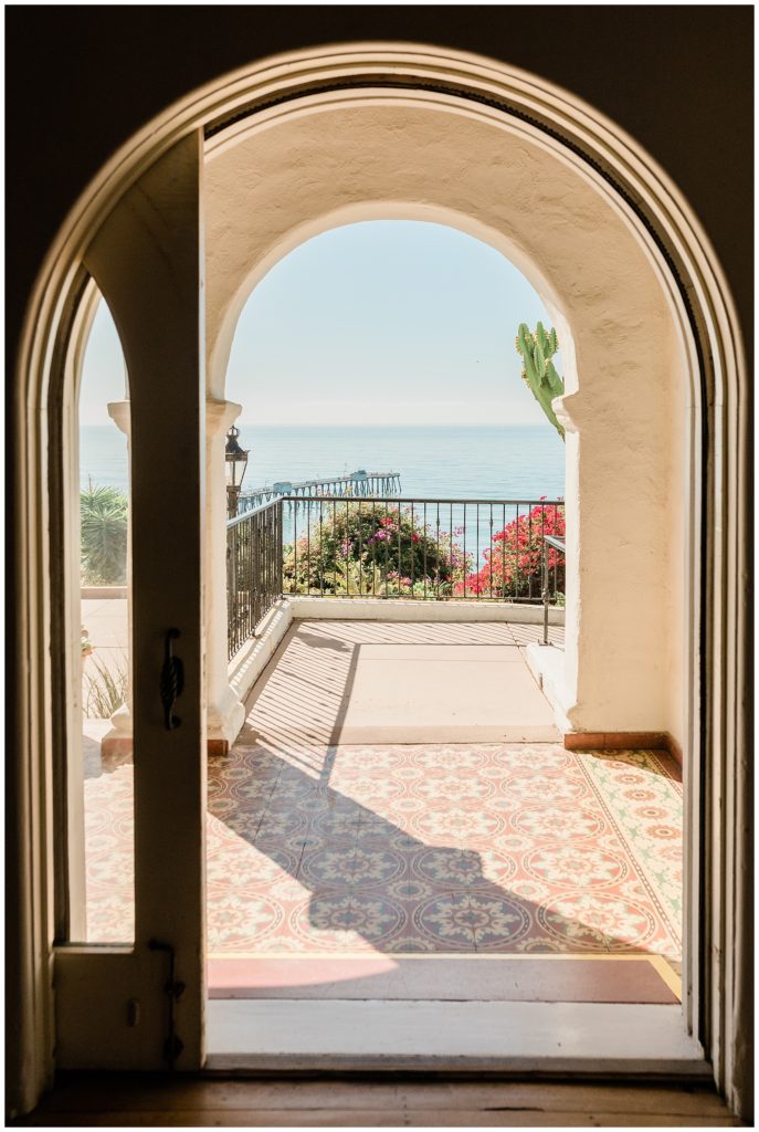 Layered arched doorways look out from the Main Salon at Casa Romantica wedding venue in Orange County, to the blue Pacific Ocean view.