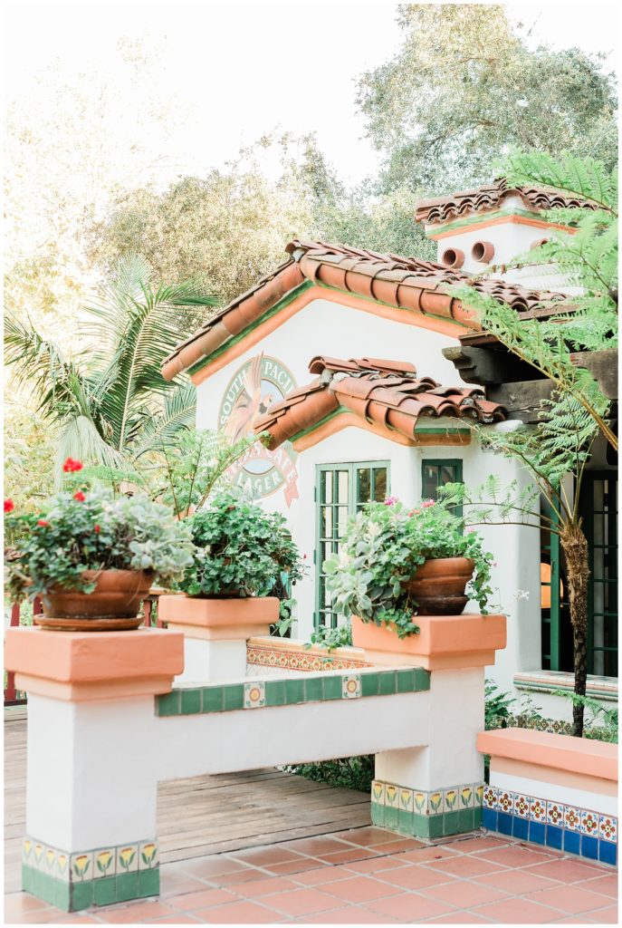 Exterior courtyard of Rick's Cafe at Rancho Las Lomas wedding venue with colorful painted tiles and lush green plants.
