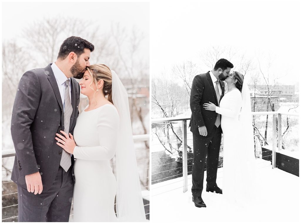 A groom kisses the bride on her forehead as the snow falls around them in Beacon NY at Roundhouse Hotel winter wedding inspiration.