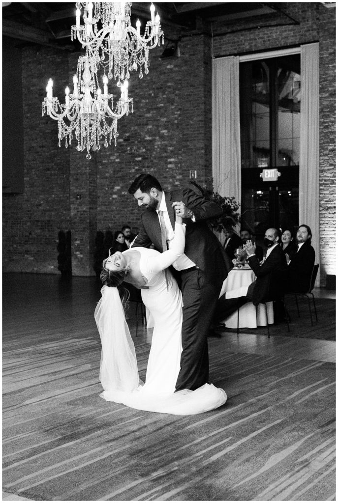 Bride and groom share a first dance and the groom dips the bride at their winter wedding in Beacon NY at Roundhouse Hotel winter wedding inspiration.in Beacon NY at Roundhouse Hotel.