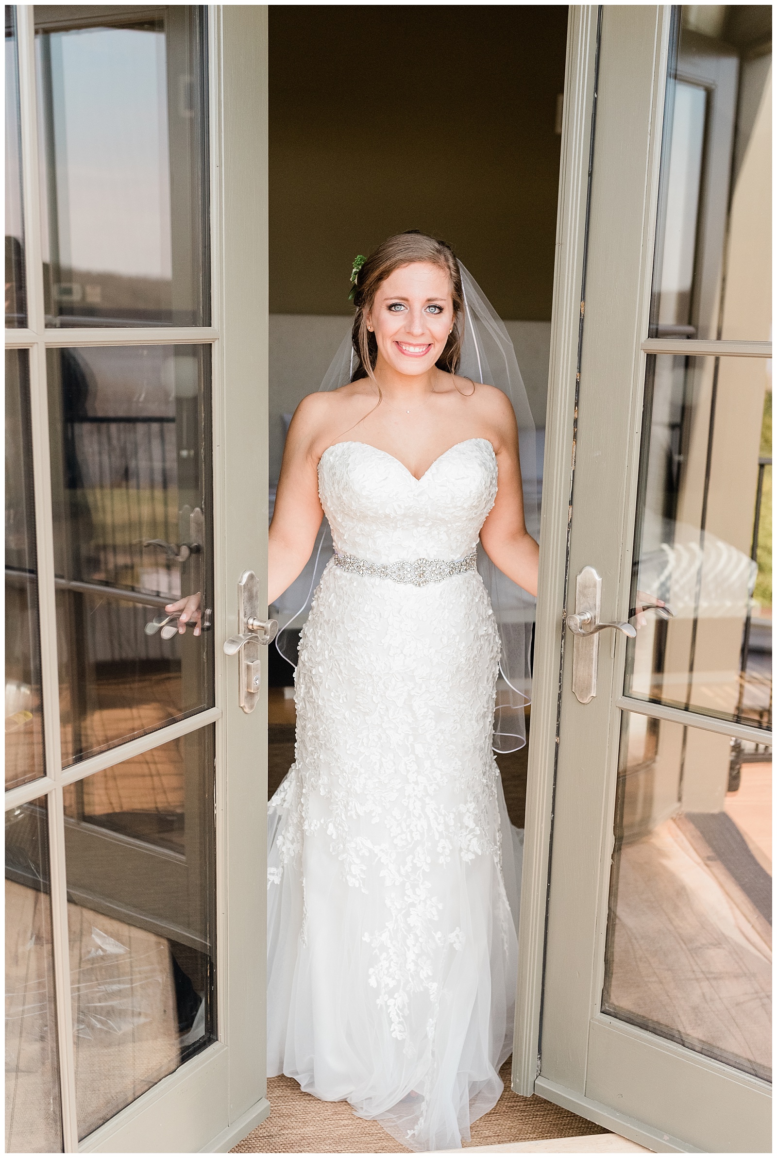 Bride opening balcony doors of the bridal suite wearing Mark Zunino wedding gown.