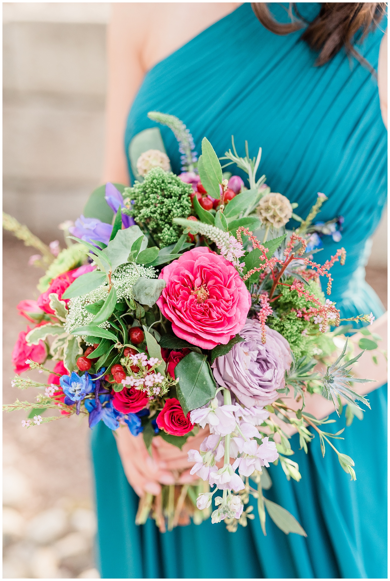 Bright colorful bridesmaid bouquet with teal dress by Buttercup Florals in Pennsylvania.