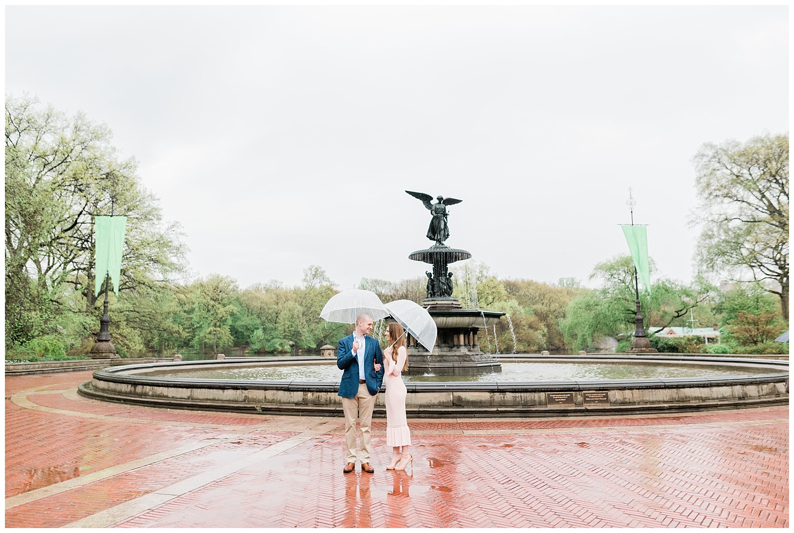 A couple holds hands under umbrellas by the Bethesda Fountain in Central Park.