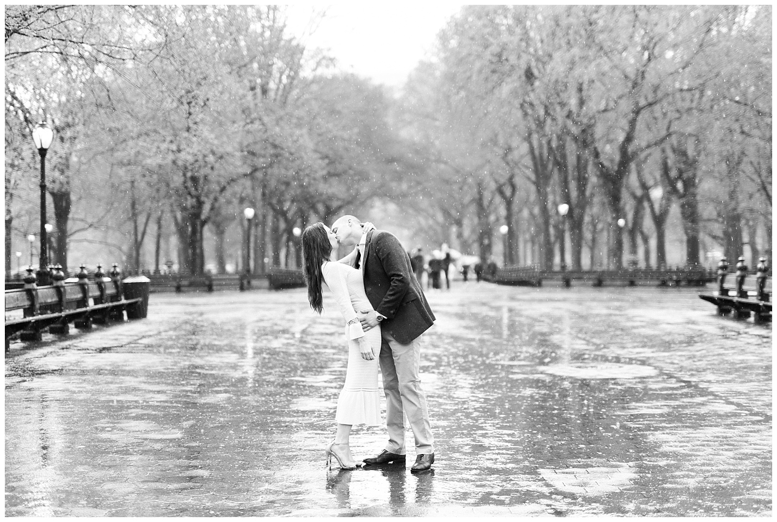 A couple kisses in the rain in the Mall at Central Park in New York City.