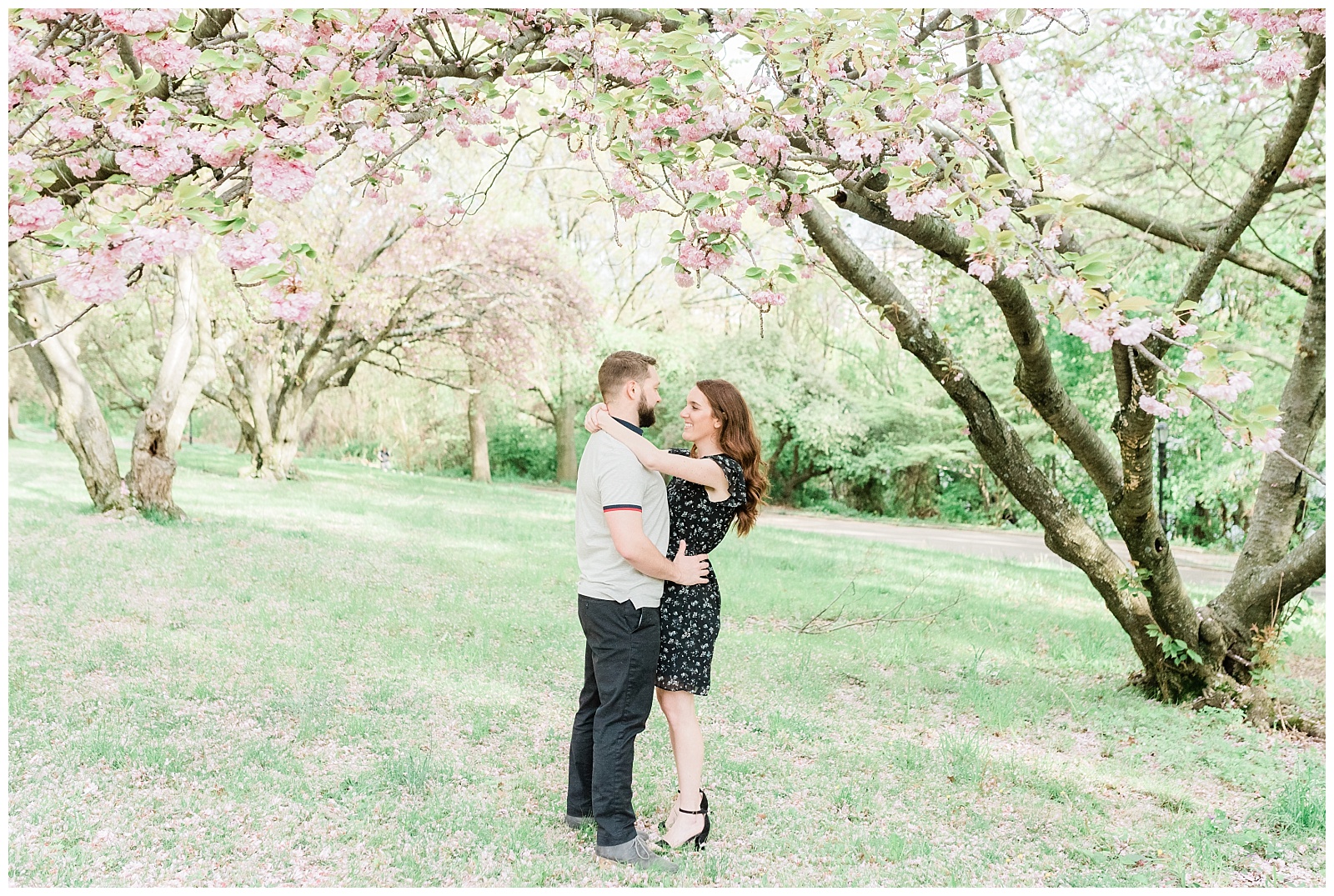 A couple slow dances beneath a cherry blossom tree.