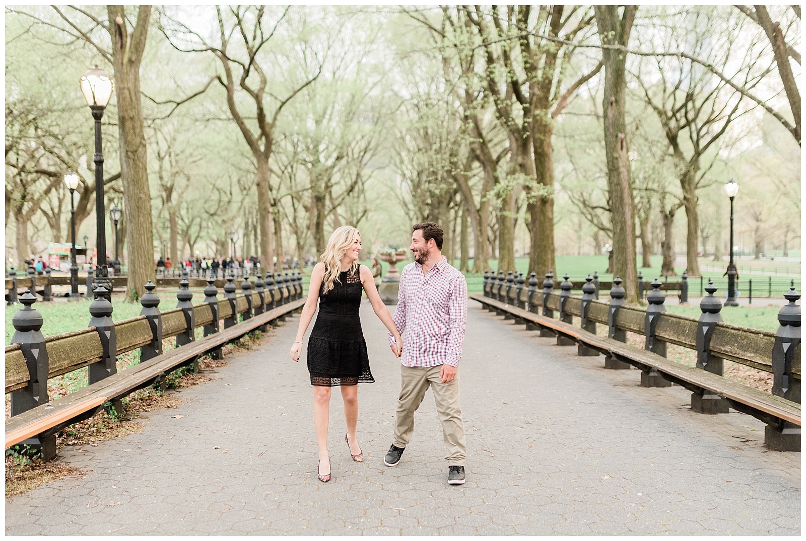 A couple walks holding hands at the Mall in Central Park.