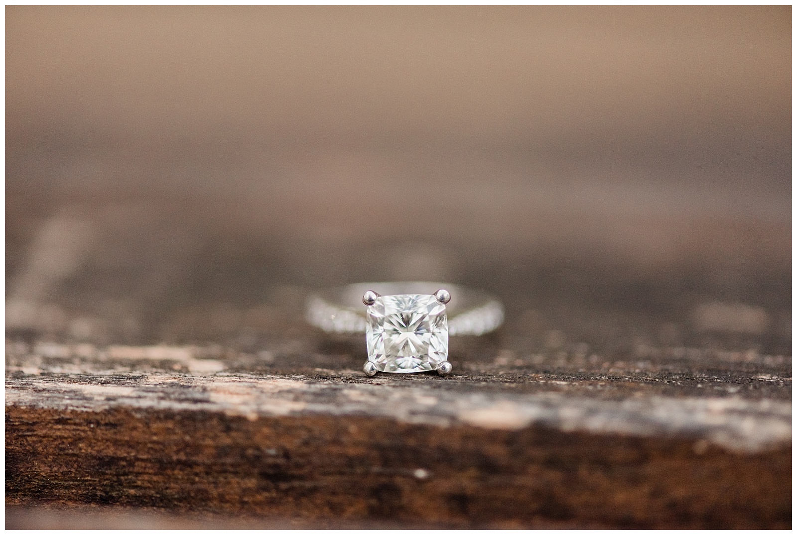 A diamond engagement ring sits on a wooden bench in NY.