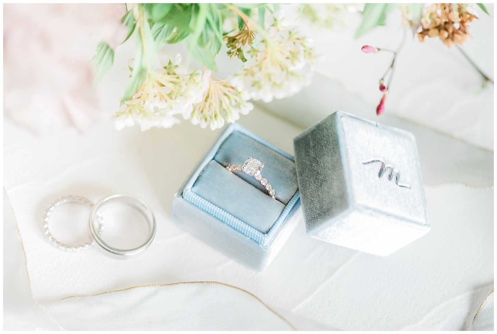 Wedding rings in a light blue velvet ring box.