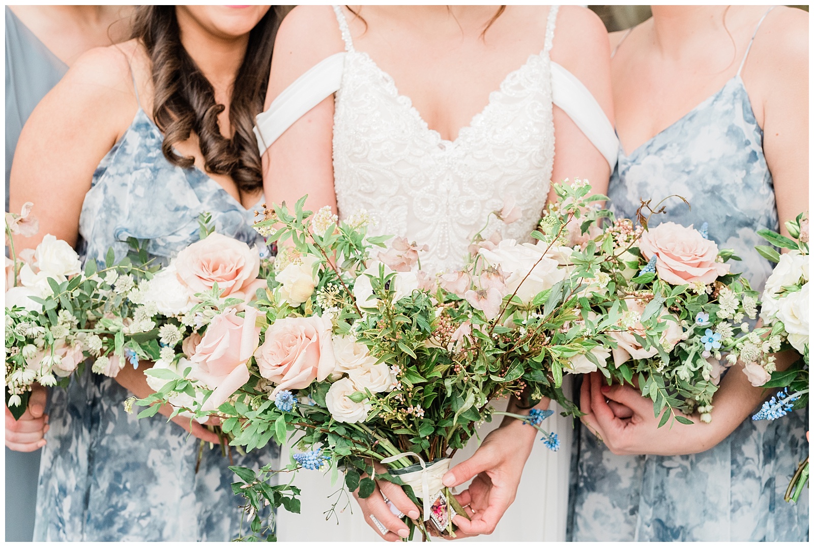 Bride and bridesmaids hold their wildflower bouquets.