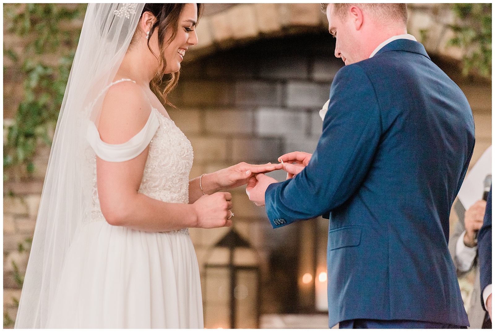 Groom puts a wedding ring on the bride's finger during the ceremony.