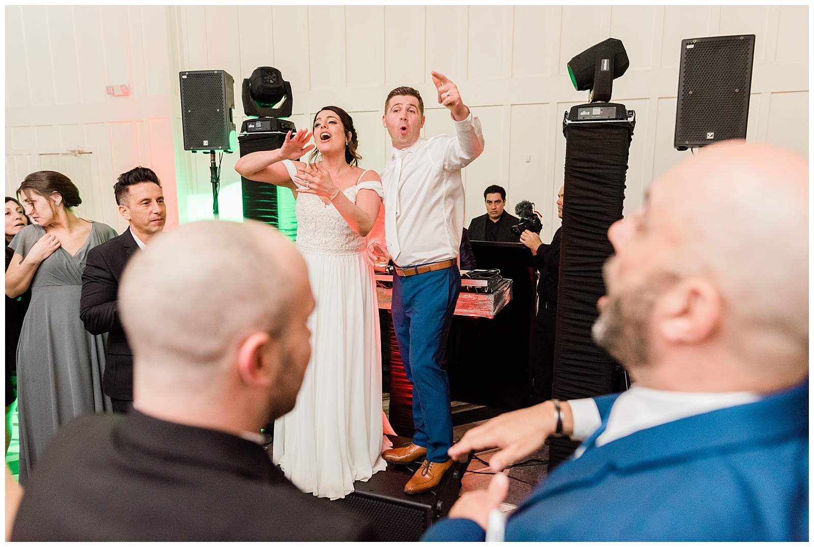 Bride and groom dance on a speaker in front of the DJ booth during the reception.