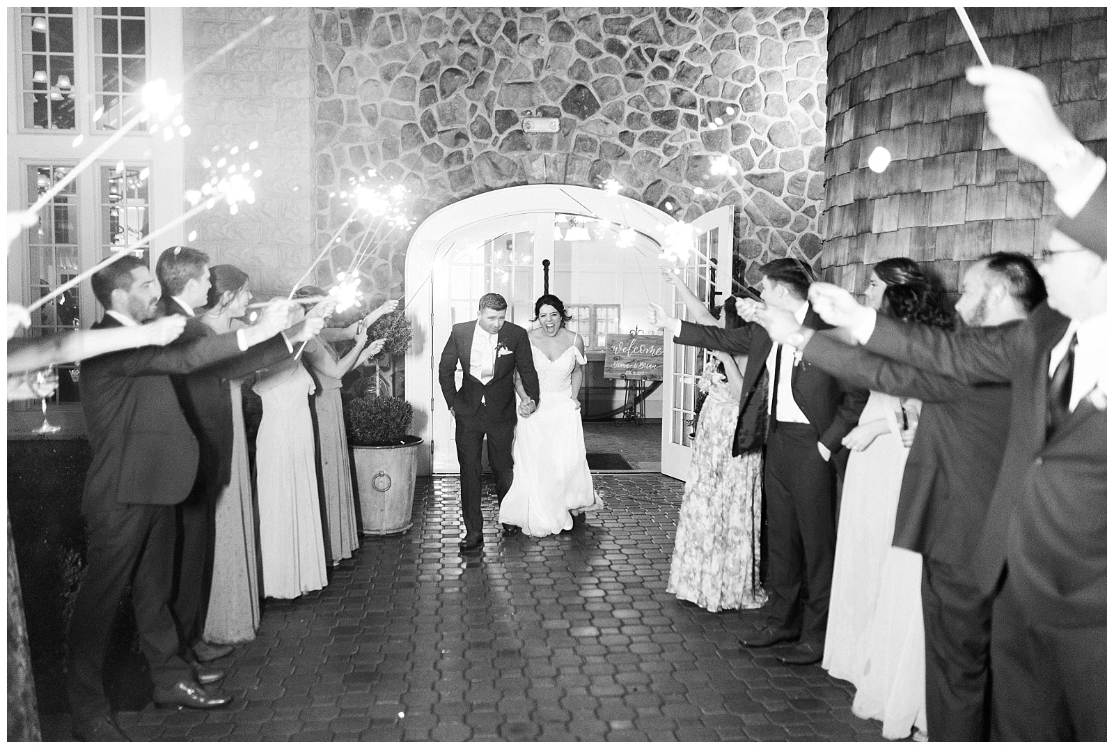 Bride and groom exit the reception through a line of sparklers held by the groomsmen and bridesmaids.
