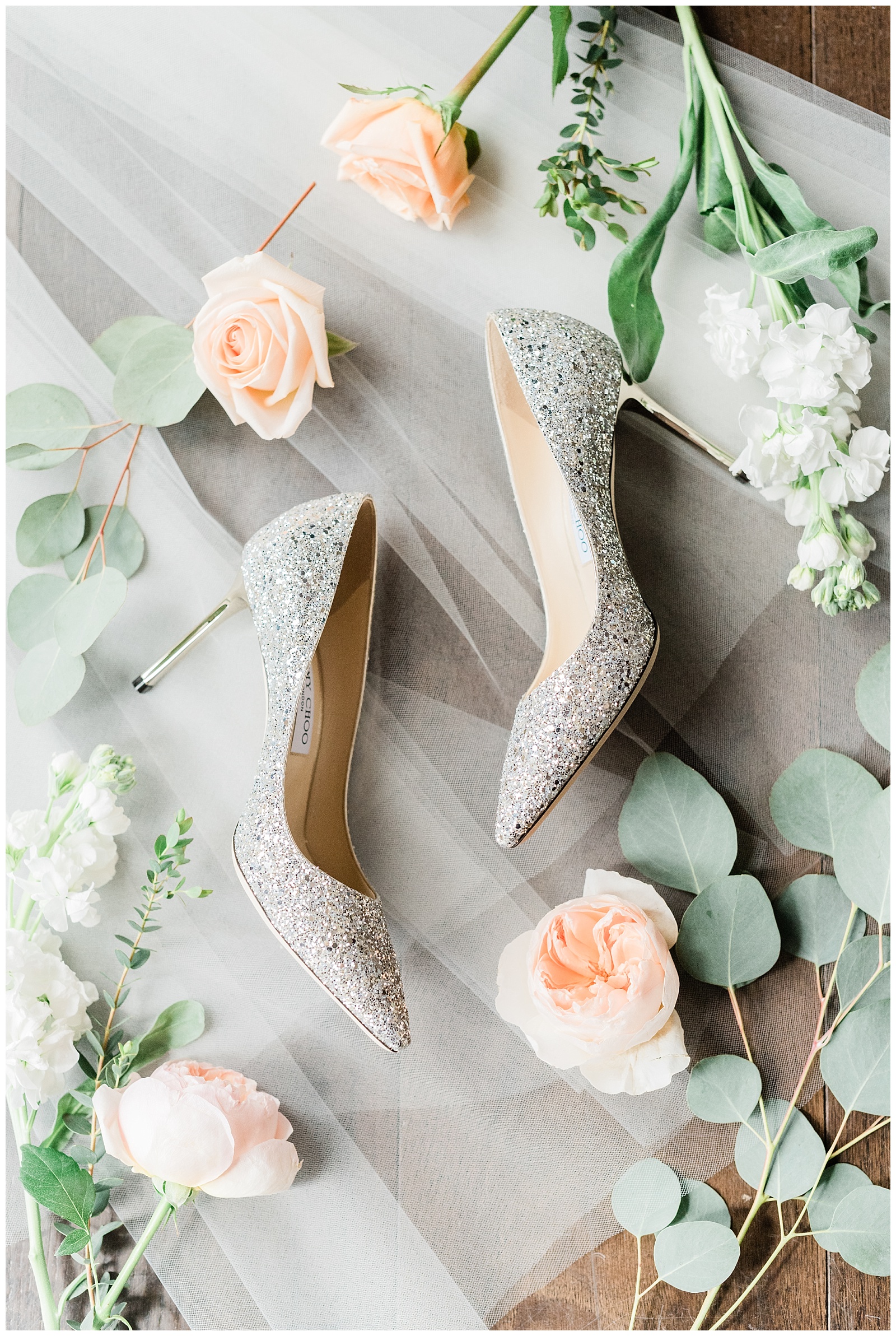 Silver sparkly Jimmy Choo high heels styled on a wedding veil with garden roses and eucalyptus leaves.