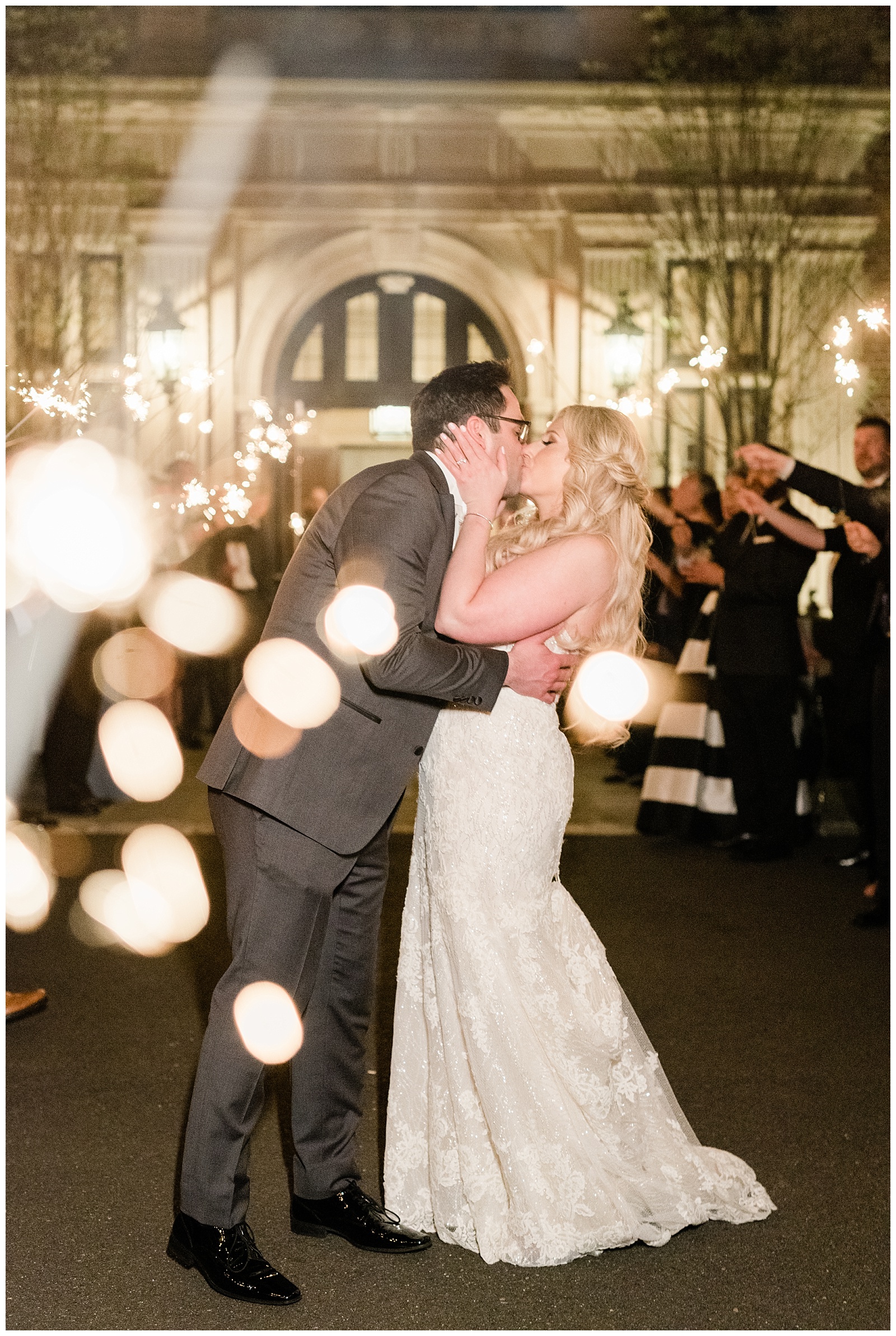 A bride and groom kiss during a sparkler sendoff outside the Mansion at Natirar at the end of their wedding day.