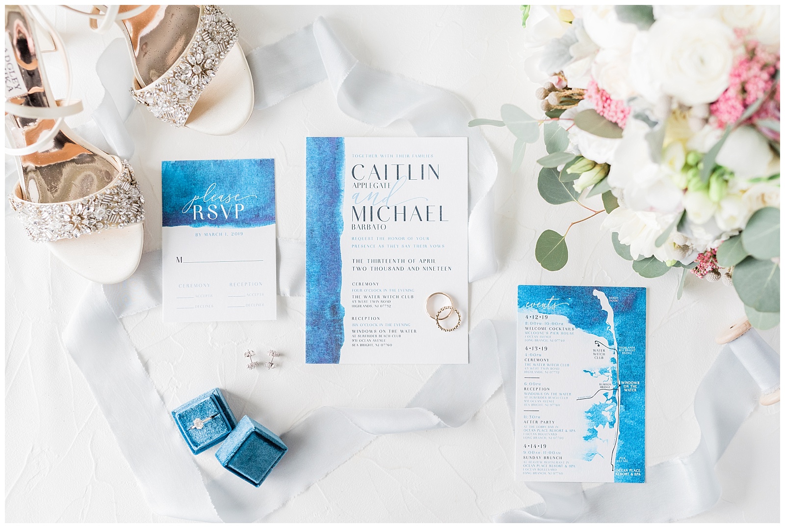 Blue wedding invitation suite styled with flowers and blue velvet ring box.