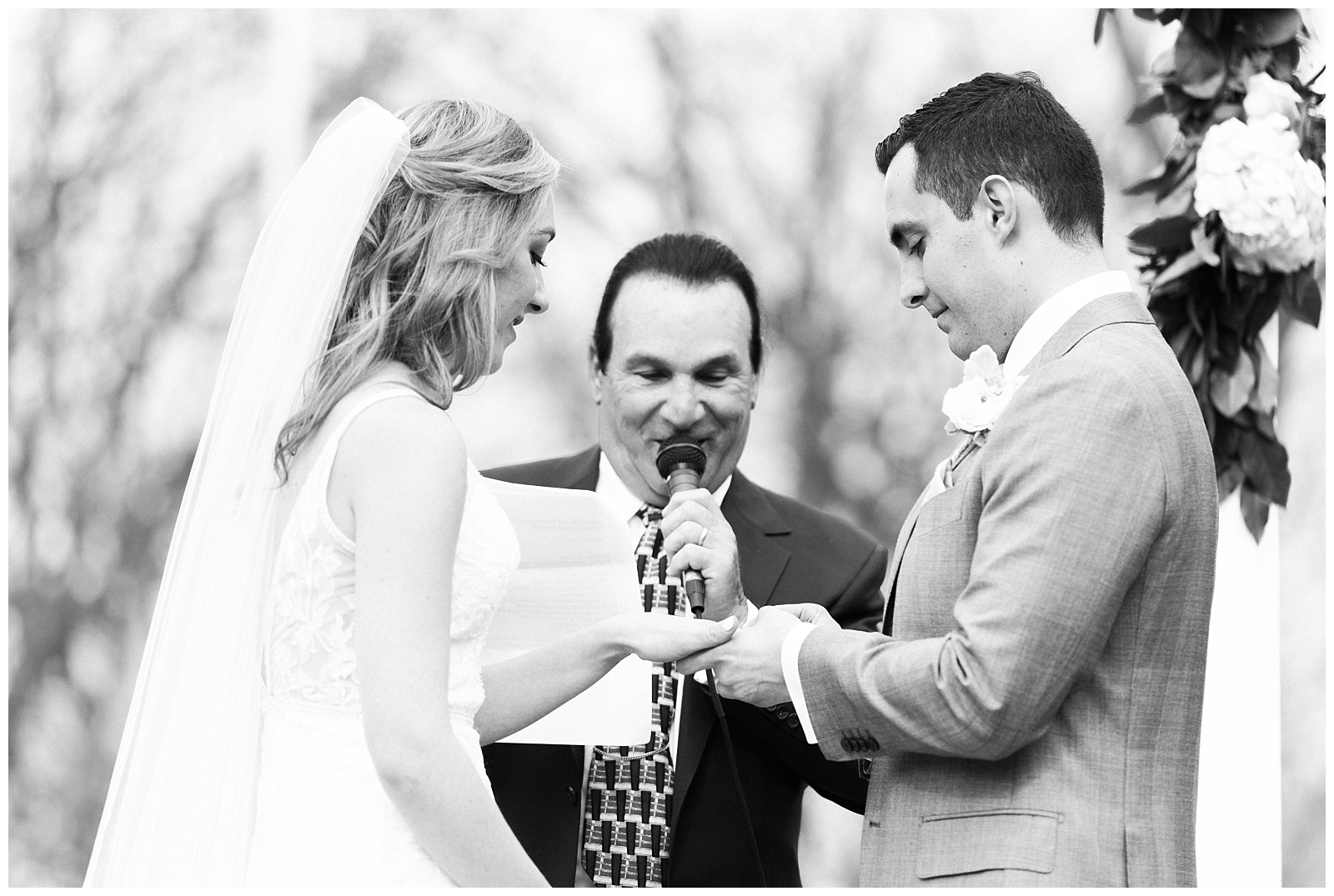 Groom puts a ring on the bride's finger during the ceremony.