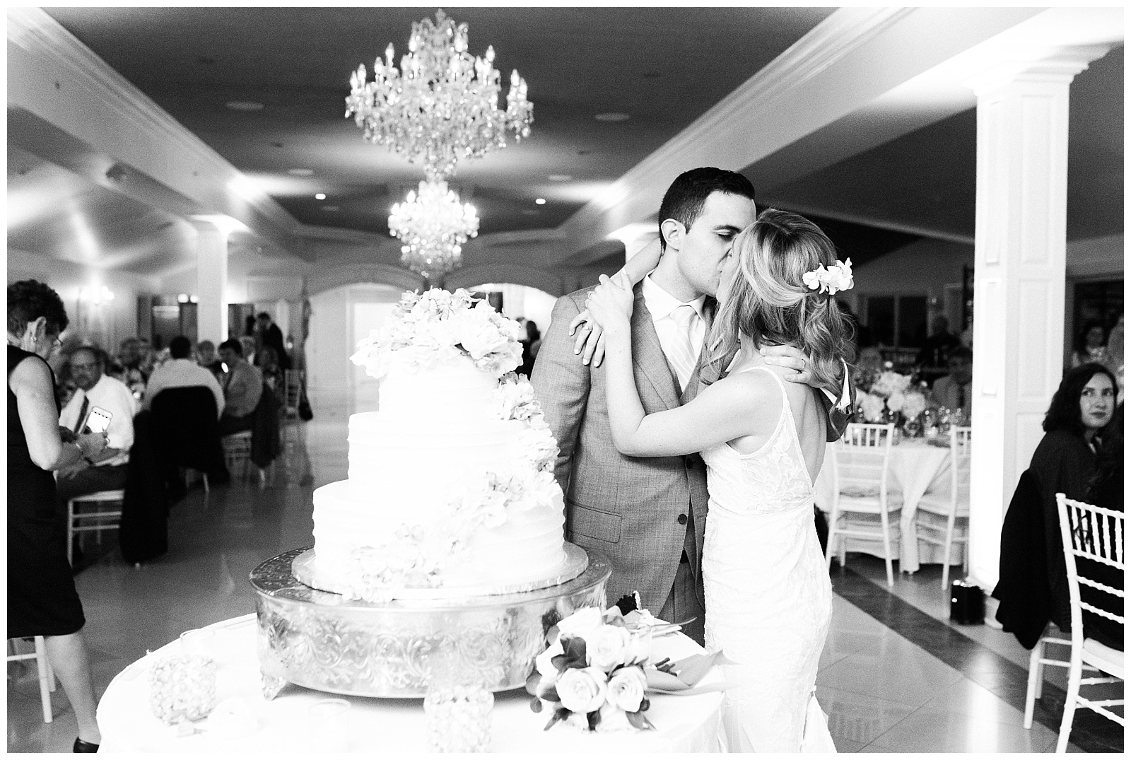 Bride and groom kiss after cutting their wedding cake at their reception.