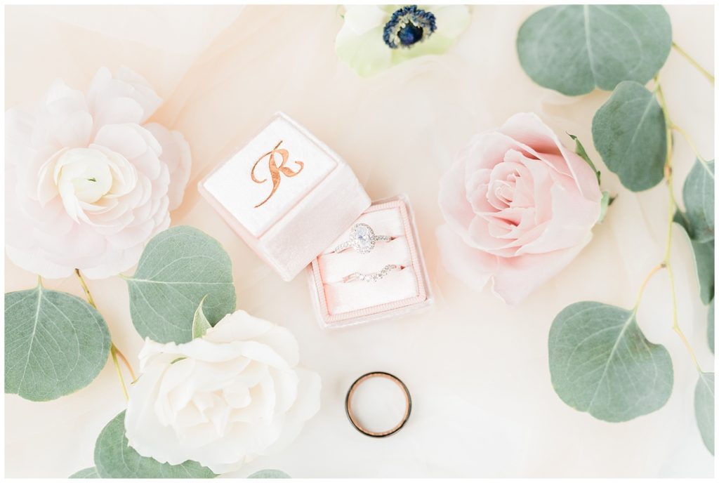 Wedding bands and an engagement ring are styled inside a Mrs Box velvet ring box.