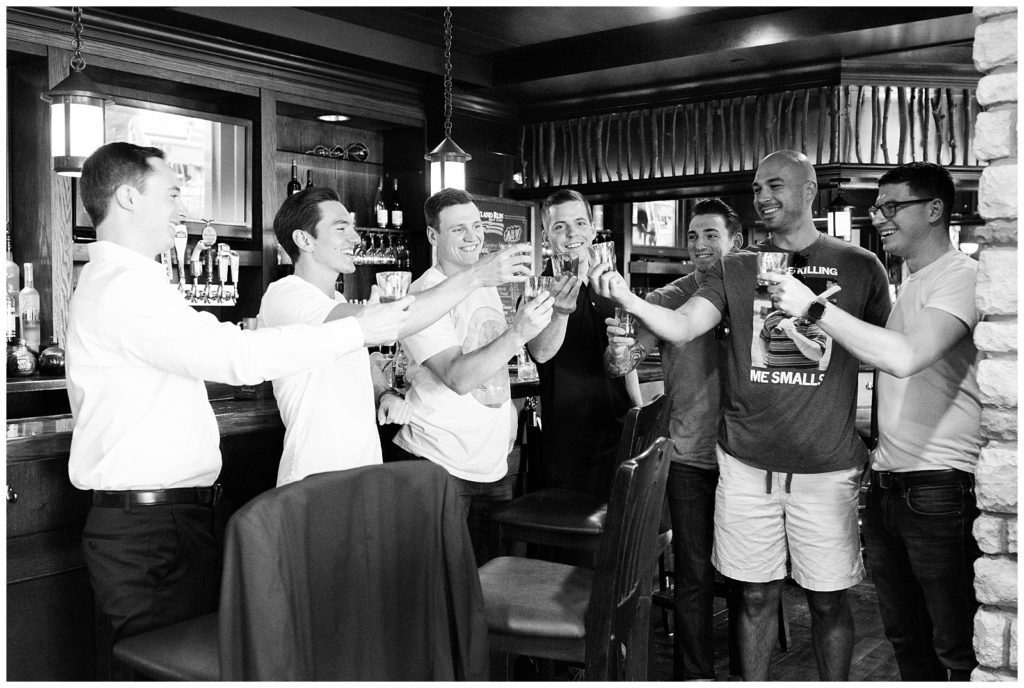 The groom and groomsmen toast in the bar on the groom's wedding day.