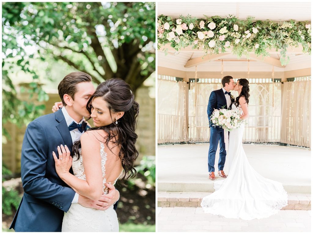 A bride and groom kiss on their wedding day beneath a floral ceremony structure.