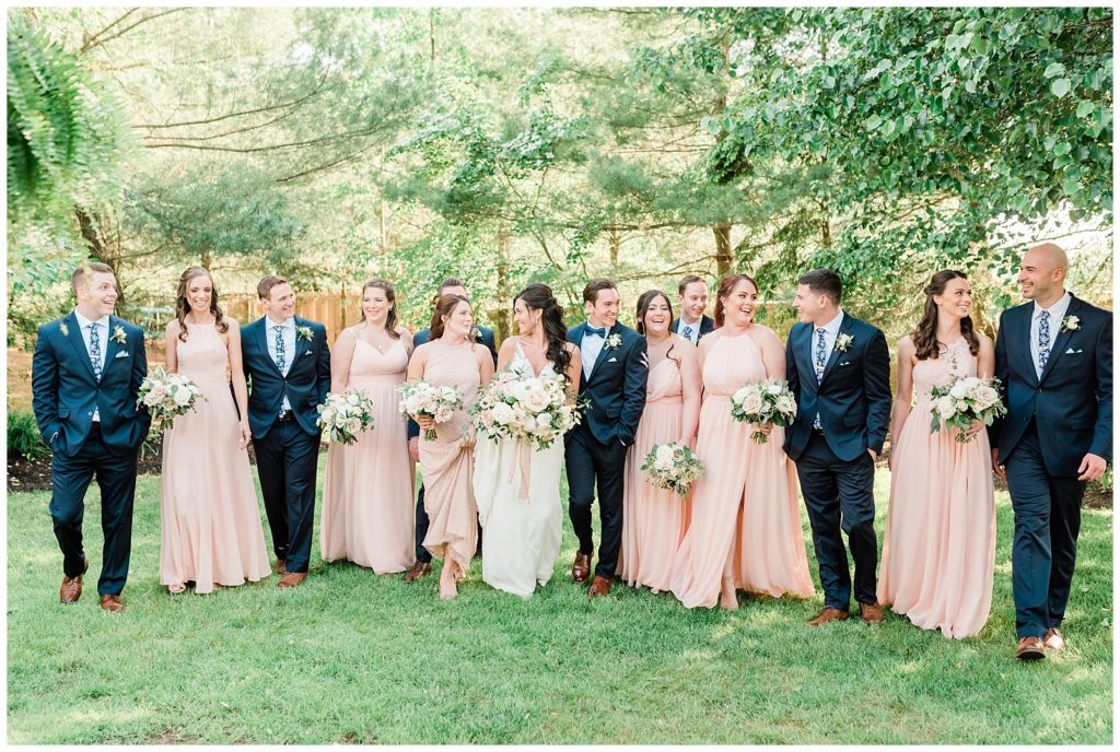 A bride and groom walk with their bridesmaids and groomsmen.