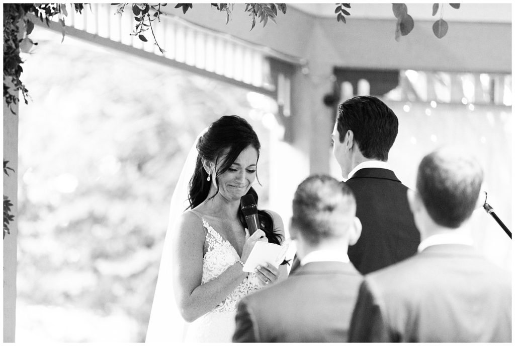 A bride reads her vows to her groom during their wedding ceremony.