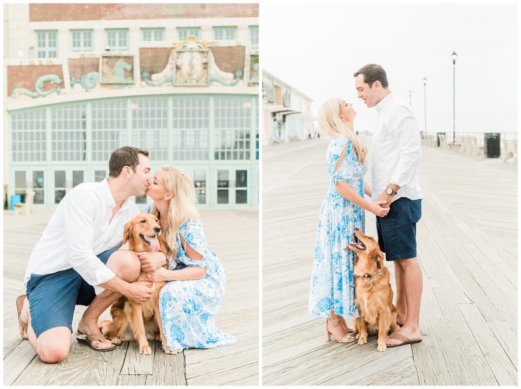 A couple kisses near their dog who is sitting on the boardwalk.