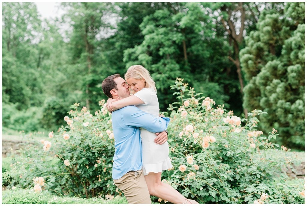 A couple hugs in a blooming garden in New Jersey.