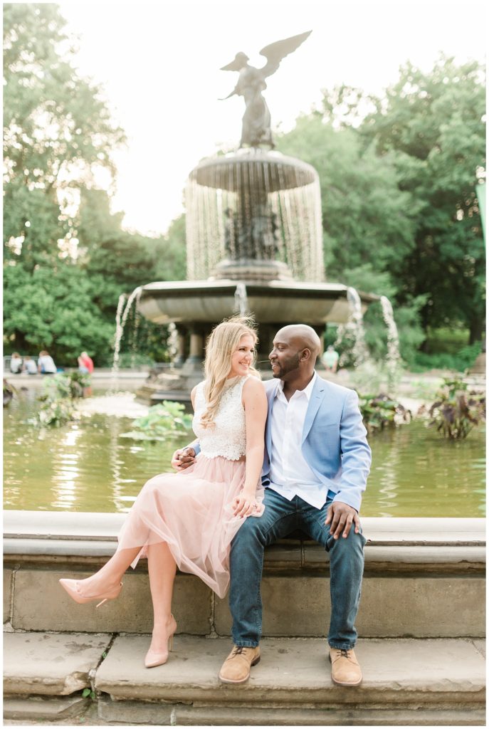 A couple sits on the edge of the Bethesda Fountain in New York City.