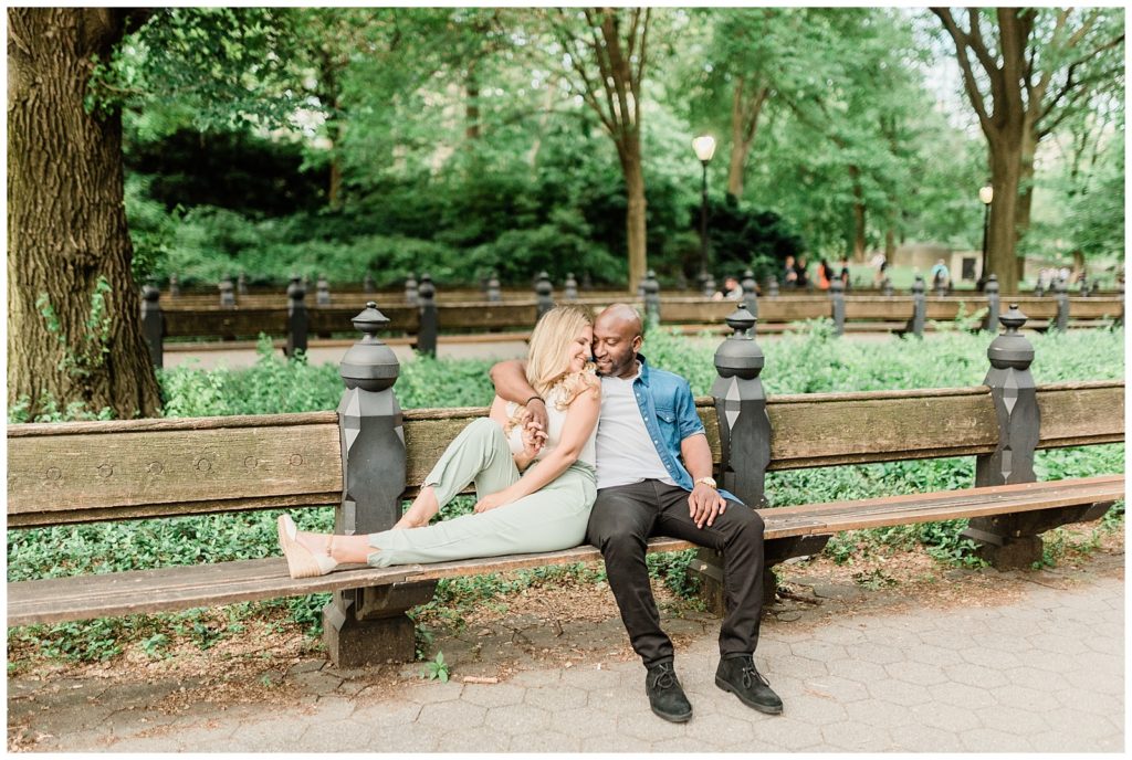 A couple sits together on a bench in Central Park.