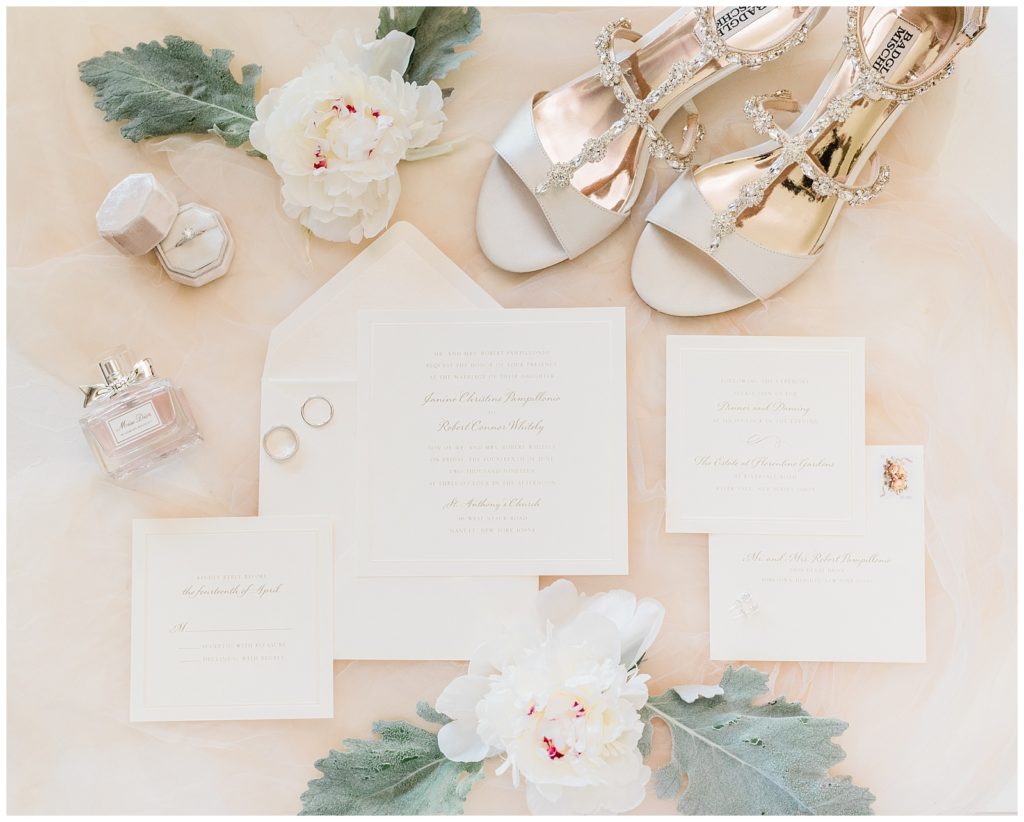 An invitation suite styled with florals and the bride's badgley mischka shoes.