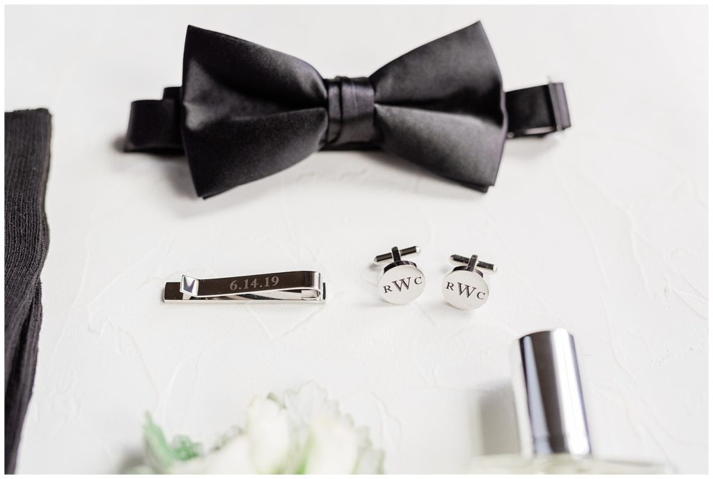 Groom details including bow tie, cuff links, and tie bar.