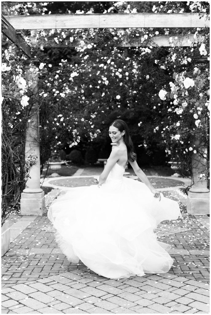 The bride twirls in her dress in the rose garden at Florentine Gardens.