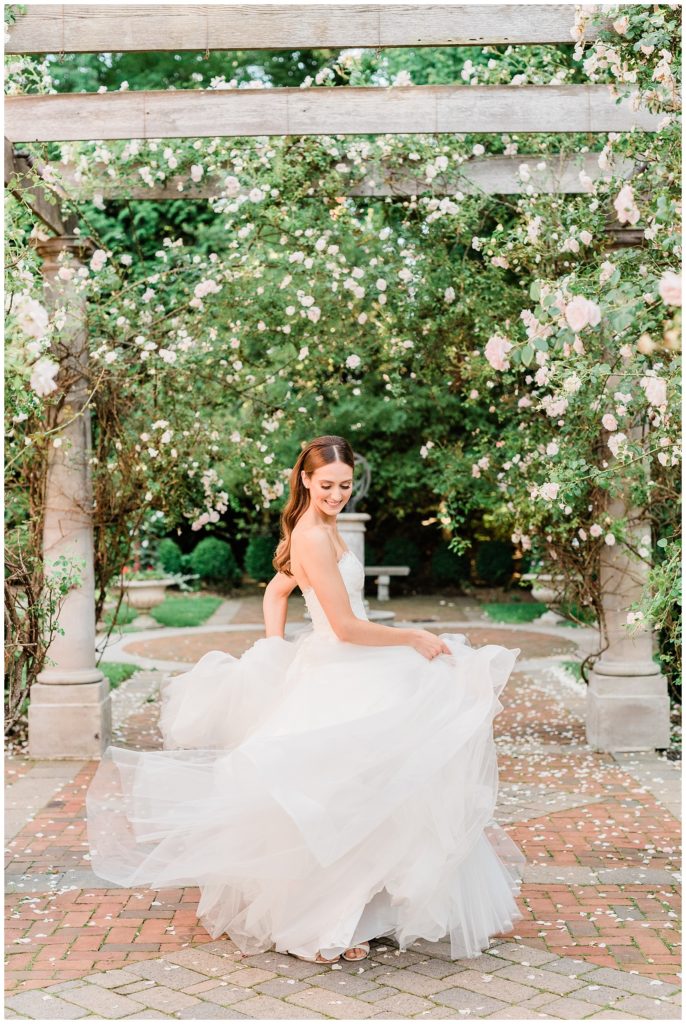 The bride twirls in her dress in the rose garden at Florentine Gardens.