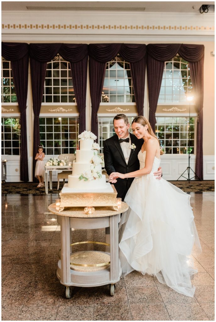 Bride and groom cut their wedding cake during their reception at the Estate at Florentine Gardens.