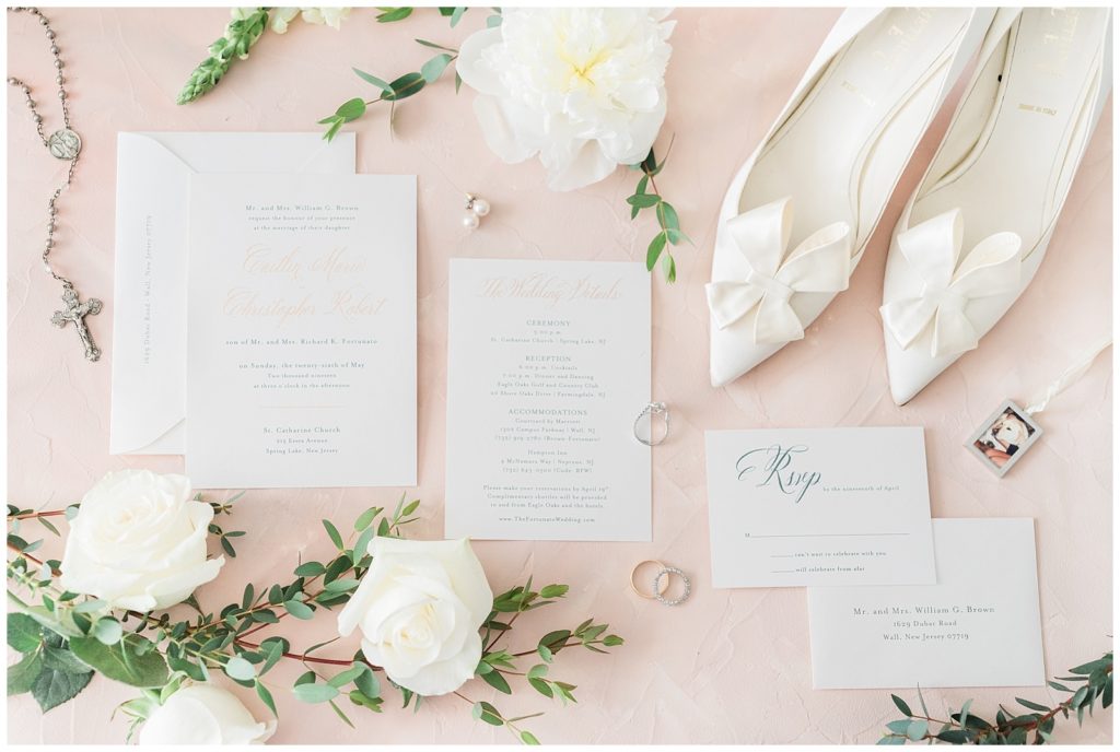 Wedding invitations styled with white bow wedding shoes and loose peony florals.