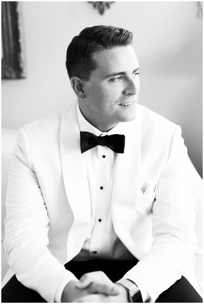 The groom poses for a portrait while wearing his wedding tux.