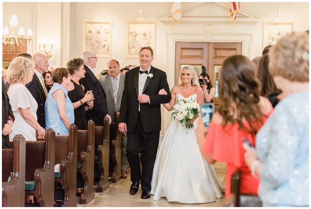 The bride's father walks her down the aisle in St. Catharine's Church in Spring Lake, NJ.