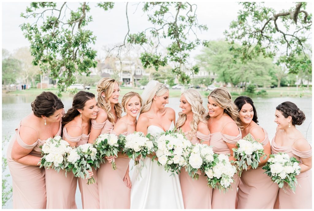 The bride and her bridesmaids smile and laugh together in Divine Park in Spring Lake.