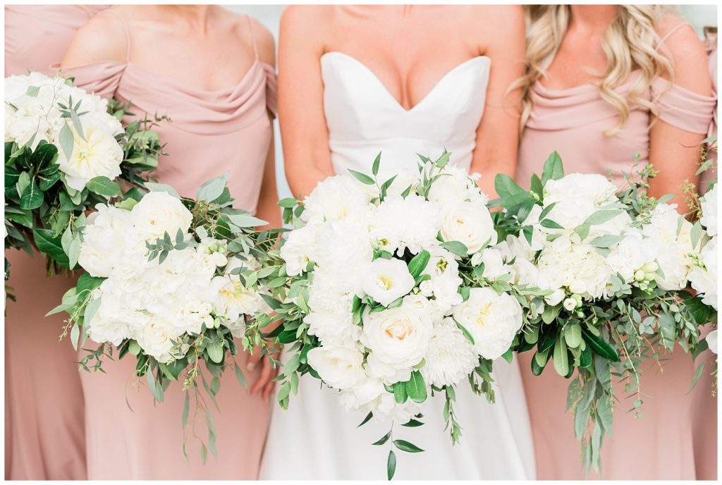 Closeup of bride and bridesmaids bouquets of white flowers and greenery by Wildflowers Florist NJ.