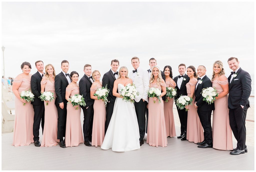 The bridal party poses for a photo on the boardwalk by Spring Lake beach.