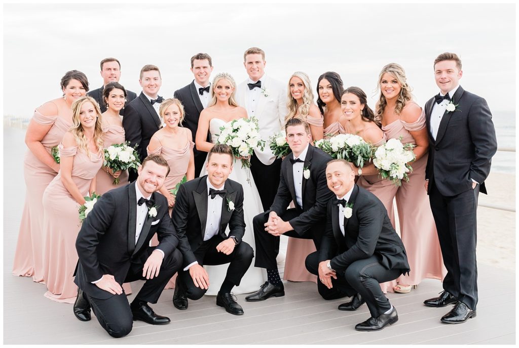 The bridesmaids and groomsmen get together for a photo on the boardwalk of Spring Lake, NJ.